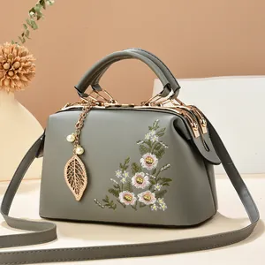 Grey tote bag with elegant floral embroidery, gold hardware and leaf pendant detail
