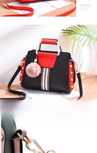 Detailed shot of contrast color handbag with pearl accents and pink fur pompom charm