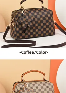Detail view of the brown checkerboard patterned Boston bag with floral motifs and charms