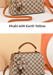 Detail of checkered canvas pillow bag with earthy yellow leather strap and gold hardware