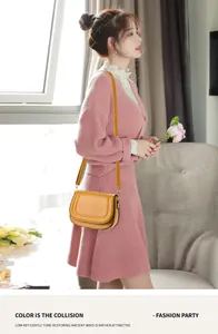 Close-up of a mustard yellow saddle bag worn with a pink knit dress by a model