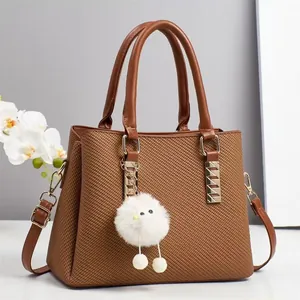 Classic dark brown woven shoulder bag with handles and a cute plush doll pendant