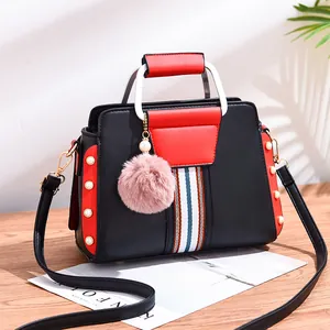 Contrast color women's handbag with white U-shaped handles and pink fur ball pendant