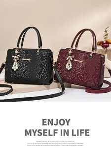 Close-up of luxury snakeskin texture on red bridal tote bag with golden charm
