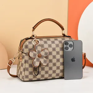 Brown checkered handbag with floral patterns, adjustable strap and flower charm accessory