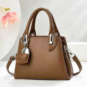 Elegant brown leather bucket bag with silver heart charm and crossbody strap