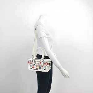 Detail of white checkered shell bag with colorful geometric blocks on a female mannequin