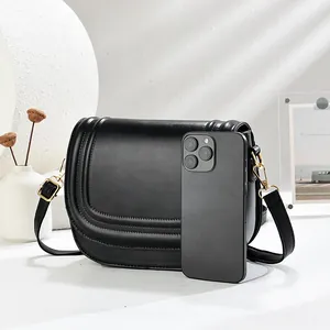 Minimalist black PU leather saddle bag with embossed lines and gold hardware for women