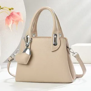 Detail of lychee pattern leather handbag with silver hardware and heart pendant charm