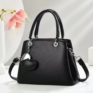 Schwarze Damen Handtasche aus Leder mit Herzanhänger und verstellbarem Schultergurt