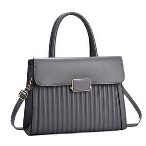 Dark grey pleated crossbody handbag with gold buckle and top handle in 45-degree view