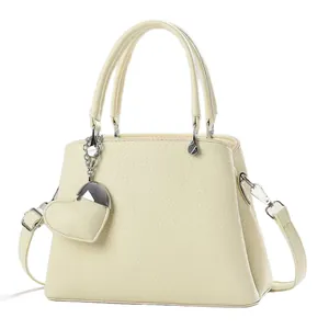 Chic beige lychee leather bucket bag with top handles and a cute heart pendant
