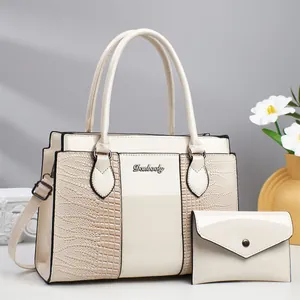 Detail of elegant crocodile-embossed texture and logo on the cream handbag set