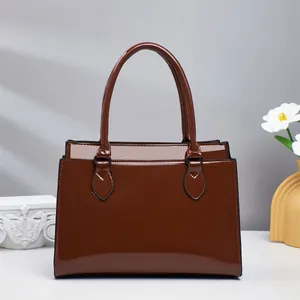 Detailed view of dark brown glossy patent leather handbag with a high-shine finish