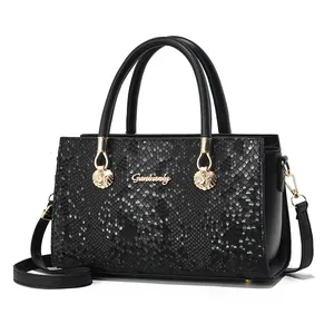 Elegante schwarze Handtasche mit Schlangenmuster, goldenem Logo und Schultergurt