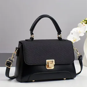 Black mixed-texture handbag with gold clasp, top handle, and detachable strap for women