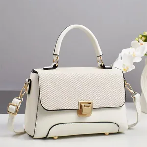 Elegant cream macaron handbag with textured flap, gold lock and detachable shoulder strap