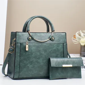Dark green leather tote bag with matching wallet, gold hardware, and top handles