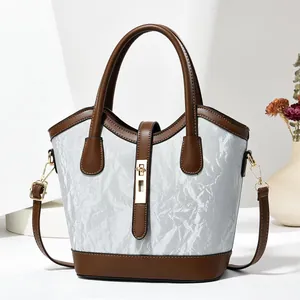 Sac à main chic plissé argenté avec bordure en cuir marron et fermoir métallique