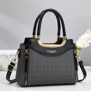 Grand sac cabas gris rayé avec poignées en cuir noir et finitions métalliques dorées
