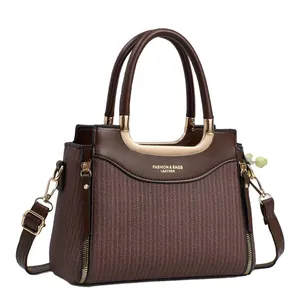 Sac à main marron en similicuir avec texture tissée et détails dorés sur fond blanc