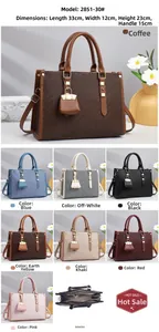 Detailed view of textured leather handbag interior, shoulder strap, and metallic charms