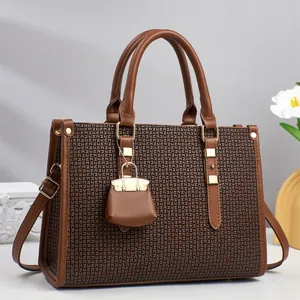 Elegant brown textured leather handbag with geometric jacquard pattern and gold hardware