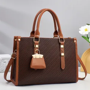 Elegant two-tone textured leather tote bag with dual handles and gold-tone charms