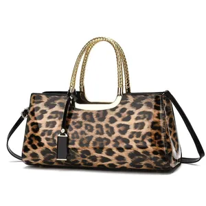 Détail du sac en cuir verni brillant léopard avec poignées tressées dorées et bandoulière