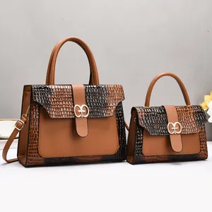 Détail de la texture crocodile marron sur le lot de deux sacs à main avec boucle dorée