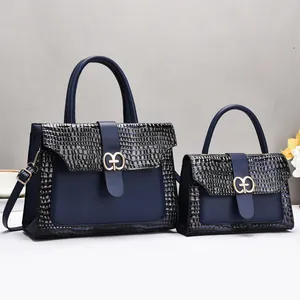 Détail de l'ensemble de sacs à main bleu marine aspect crocodile et fermoir doré