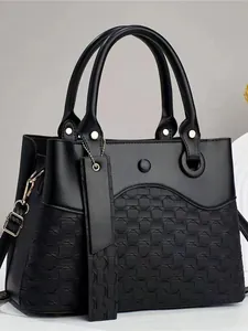 Minimalist black leather tote bag with woven texture and gold-toned metal hardware