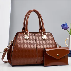 Detalle del bolso shopper en cuero charol marrón oscuro y sobre a juego con diseño acolchado