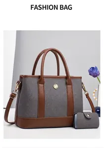 Detail of grey textured tote bag with brown leather trim and gold floral metal hardware
