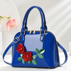 Sac coque en cuir verni bleu avec appliques florales et bandoulière réglable
