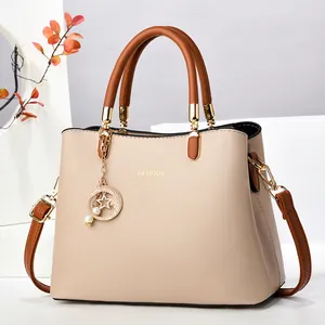 Sac à main élégant en cuir beige avec anses marron et breloque perle étoile
