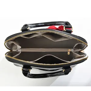 Vue détaillée de l'intérieur d'un sac à main en cuir verni avec compartiment zippé central