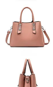 Detail view of pink crossbody bag with silver chain, round handles and leather texture