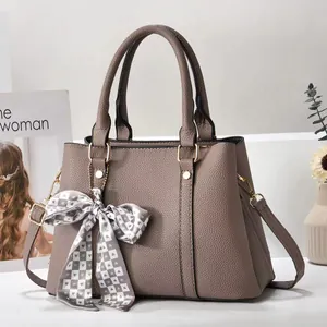 Taupe textured leather handbag with gold hardware and stylish checkered ribbon decoration