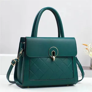 Sac à main en cuir vert foncé avec surpiqûres en losanges et fermoir doré chic