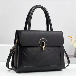 Sac à main élégant en cuir noir matelassé avec fermoir doré et bandoulière réglable