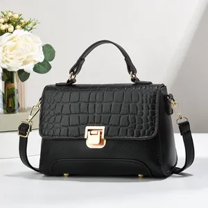 Détail en cuir noir grainé et gaufré croco avec fermoir rotatif et garniture dorée