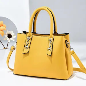 Chic yellow trapezoid handbag with silver chain accents and adjustable shoulder strap