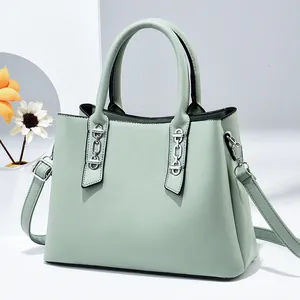 Light green trapezoid handbag with silver chain accents and a detachable shoulder strap