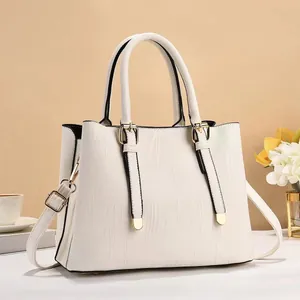 Elegant off-white striped bucket tote bag with gold buckle straps and adjustable shoulder strap