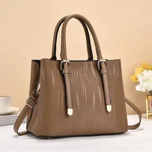 Detail view of brown textured bucket bag with striped surface and adjustable shoulder strap