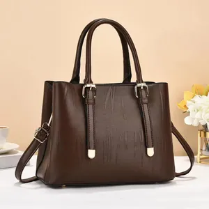 Close-up of brown striped bucket bag featuring golden hardware and leather tassels