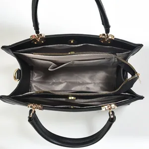 Interior view of black leather tote bag with gray herringbone lining and compartments