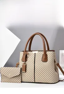 Dettaglio della borsa tote beige con stampa a croce nera e manici in pelle marrone