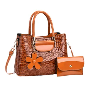Brown patent leather bucket bag with crocodile texture and matching small pouch